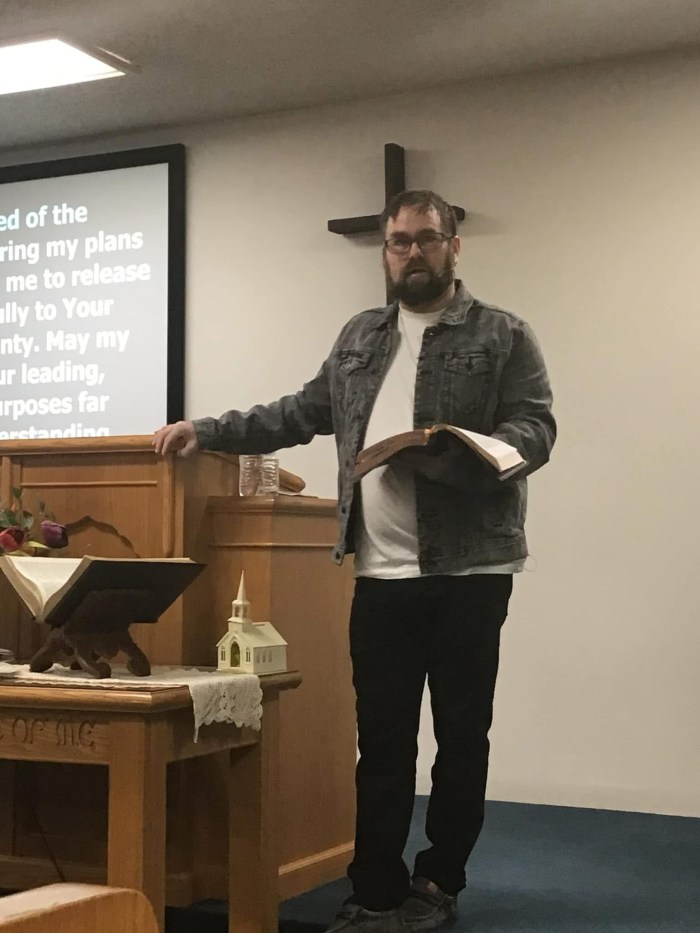 Kris preaching with his Bible